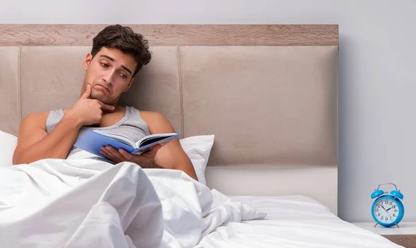 Homem leitura livro na cama — Fotografia de Stock