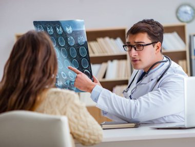 Genç doktor bilgisayardaki röntgen görüntülerine bakıyor.
