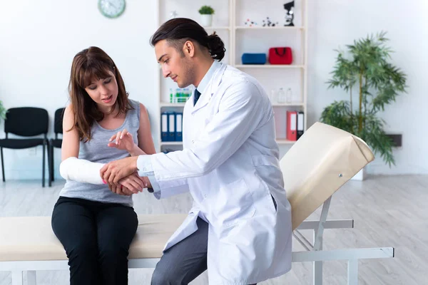 Mujer joven visitando médico traumatólogo masculino — Foto de Stock