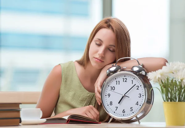 Student with gian alarm clock preparing for exams — Stock Photo, Image