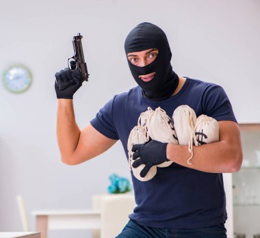 Soyguncu kar maskesi takıp değerli şeyler çalıyor.