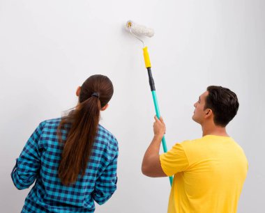 Genç aile boyama duvarları DIY kavramında