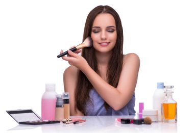 Beyazlar içinde makyaj yapan kadın.