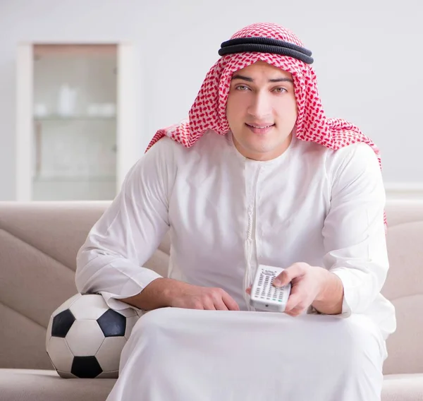 Hombre árabe joven viendo fútbol sentado en el sofá — Foto de Stock