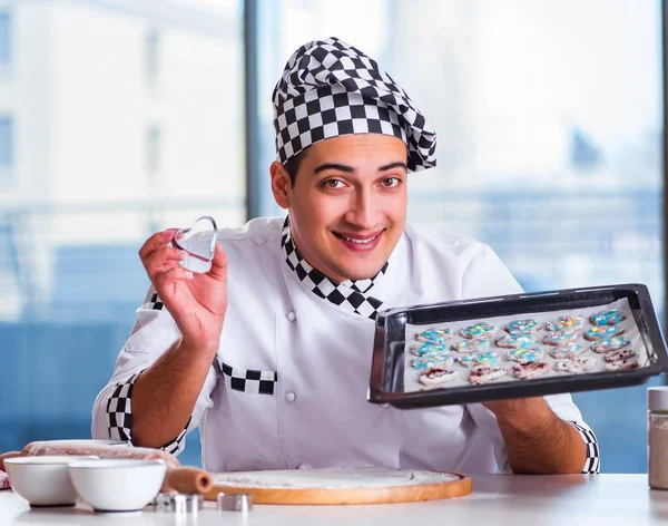 Young man cooking cookies in kitchen