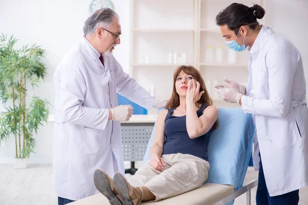 Two male doctors and young woman in plastic surgery concept — Stock Photo, Image