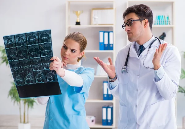 Два врача осматривают рентгеновские снимки пациента для диагностики — стоковое фото