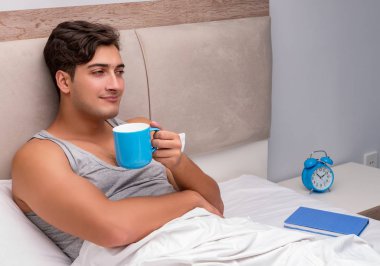 Adam yatakta kitap okumak