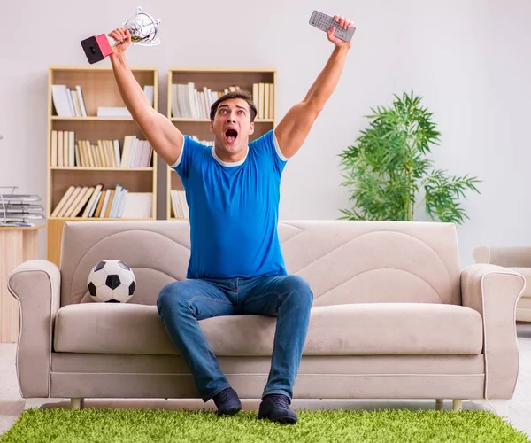 Hombre viendo fútbol en casa sentado en el sofá —  Fotos de Stock