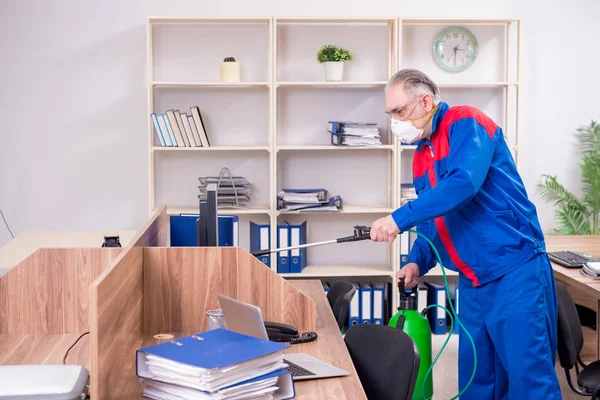 Ancien entrepreneur professionnel faisant de la lutte antiparasitaire au bureau — Photo