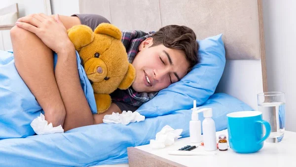 Больной человек с гриппом лежит в постели — стоковое фото