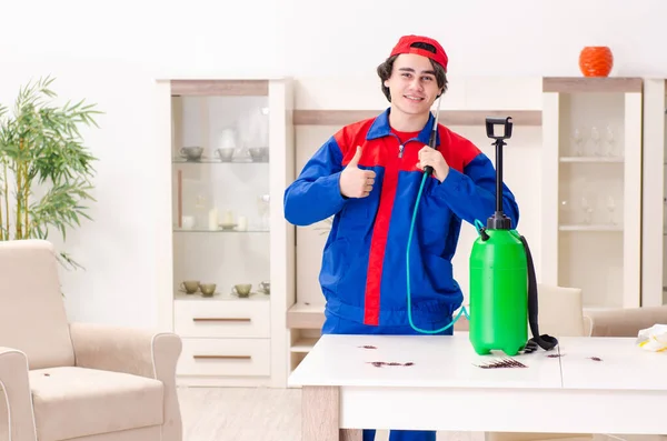 Jovem empreiteiro fazendo controle de pragas em casa — Fotografia de Stock