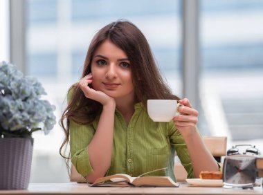 Sınavlara hazırlanan genç öğrenci çay içiyor.