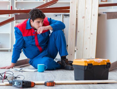 İnşaatta defter planlama yapan genç bir marangoz.