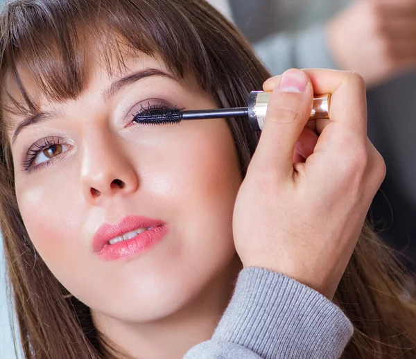 O homem fazendo maquiagem para a mulher bonita no salão de beleza — Fotografia de Stock