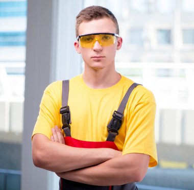 Sarı tulumlu genç inşaat işçisi.