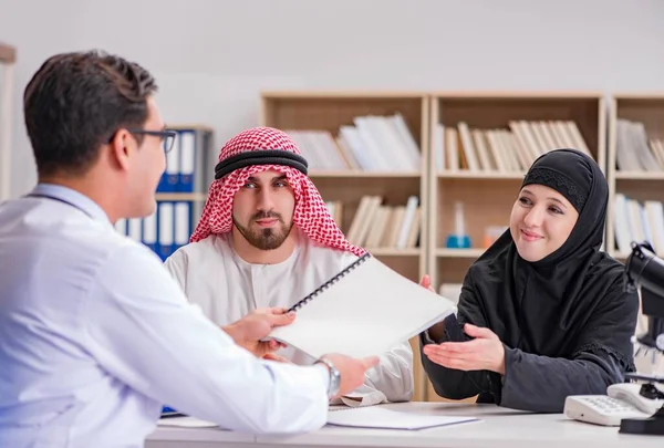 Doctor consulting arab family at hospital