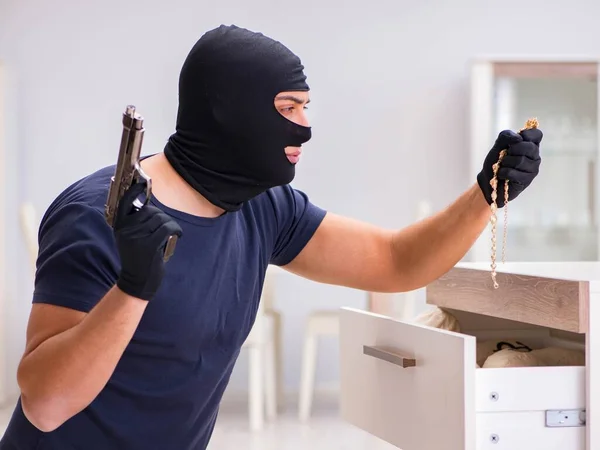 Ladrão usando balaclava roubando coisas valiosas — Fotografia de Stock