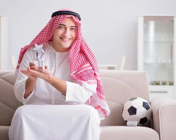 Ung arabisk man tittar på fotboll sitter på soffan — Stockfoto