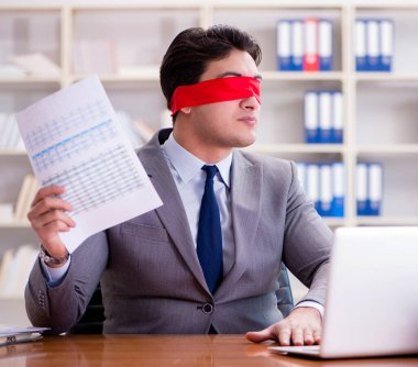 Ofiste masasında oturan gözü bağlı iş adamı.