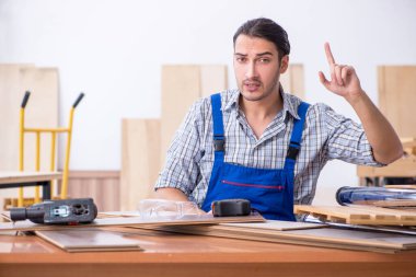 Genç erkek marangoz içeride çalışıyor.