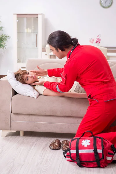 Joven paramédico masculino visitando a mujer joven — Foto de Stock