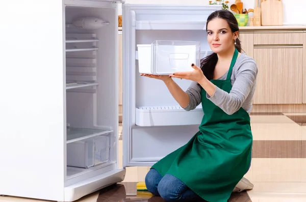 Hijyen konseptinde buzdolabını temizleyen genç bir kadın. — Stok fotoğraf