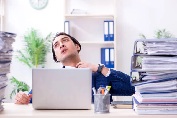 Giovane dipendente maschio infelice con il lavoro eccessivo — Foto Stock