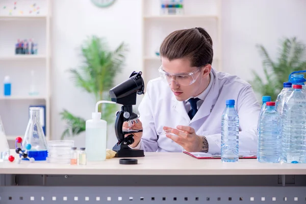 Молодий хімік-чоловік експериментує в лабораторії — стокове фото