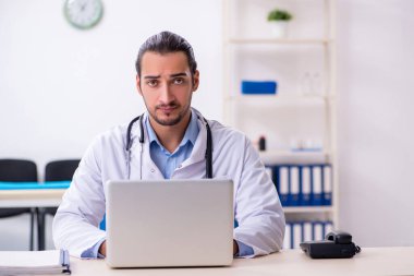 Klinikte çalışan yakışıklı genç erkek doktor.