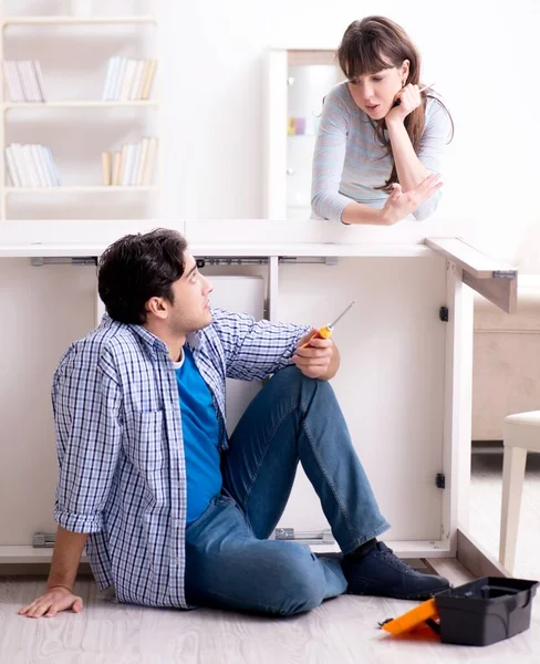 Husband repairing broken table at home — Stock Photo, Image