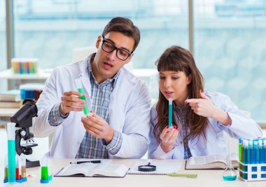 Laboratuvarda deney yapan iki kimyager.