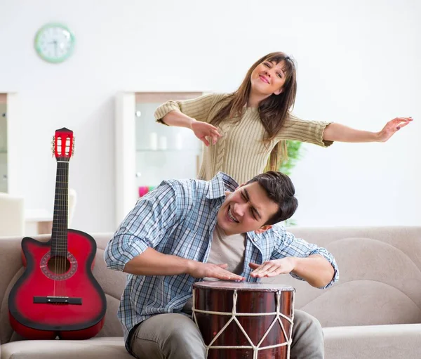 Joven familia cantando y tocando música en casa — Foto de Stock