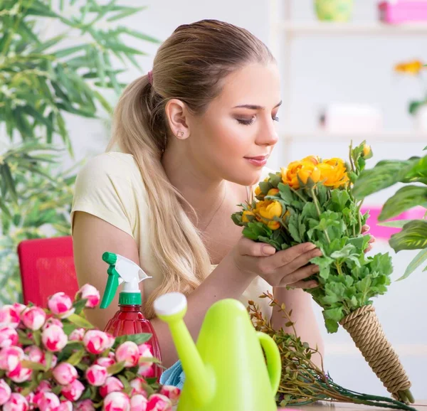 Mujer joven regando plantas en su jardín — Foto de Stock