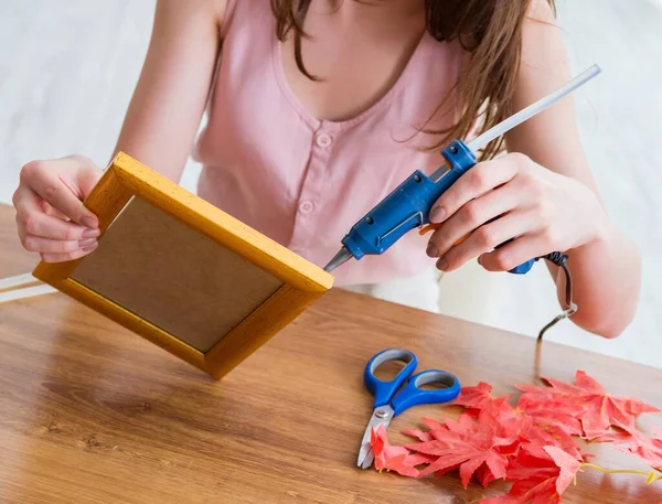 Woman decorating picture frame in scrapbooking concept — Stock Photo, Image