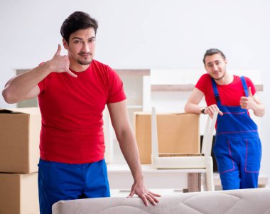 İki müteahhit personel kişisel eşyalarını taşıyor.