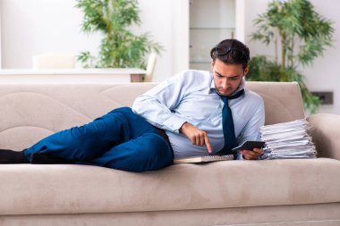 Genç erkek işadamı evde çalışıyor.