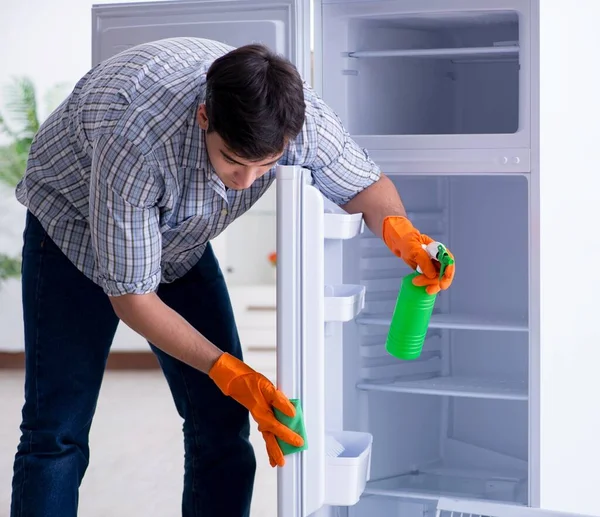 Hombre limpieza nevera en concepto de higiene —  Fotos de Stock