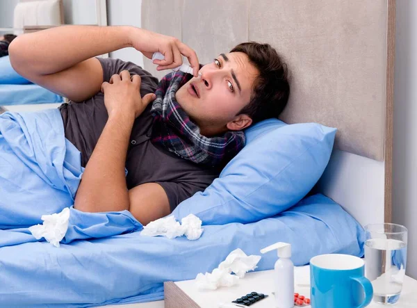 Zieke man in bed die medicijnen en drugs gebruikt — Stockfoto