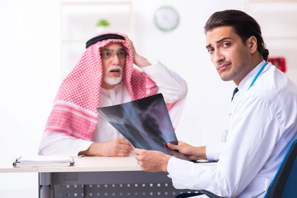 Old male arab visiting young male doctor — Stock Fotó