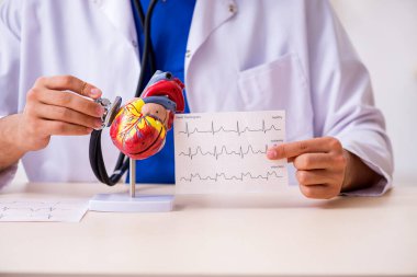 Klinikte çalışan genç bir erkek kardiyolog.