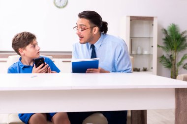 Baba oğlunun sınava hazırlanmasına yardım ediyor.