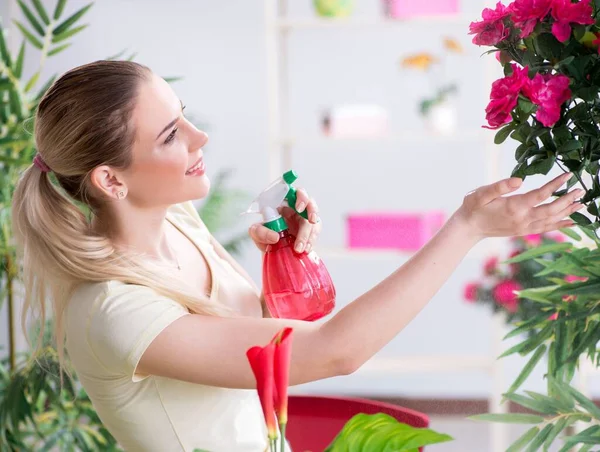 Mujer joven regando plantas en su jardín — Foto de Stock