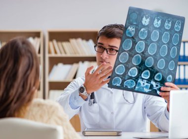 Genç doktor bilgisayardaki röntgen görüntülerine bakıyor.