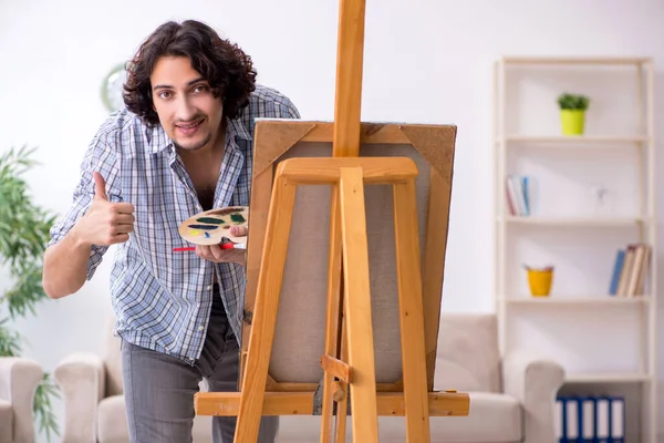 Jovem homem bonito curtindo pintura em casa — Fotografia de Stock