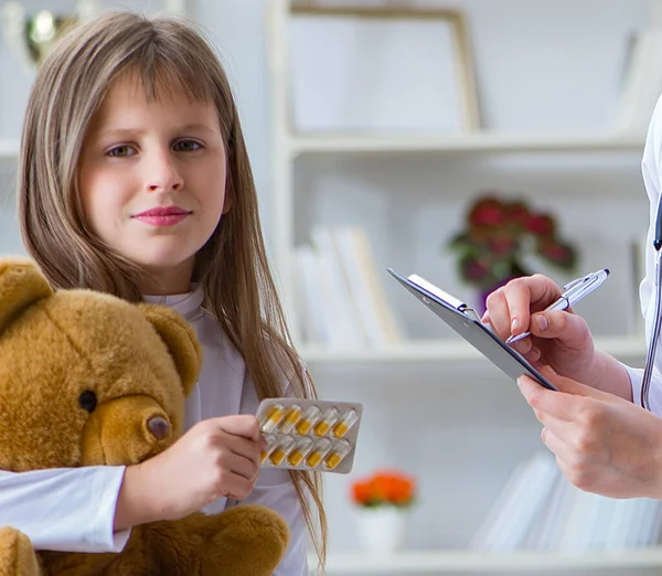 장난감 곰이 있는 귀여운 소녀를 진찰하고 있는 여의사 — 스톡 사진