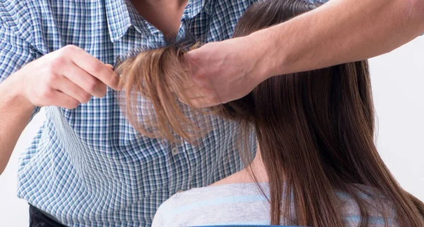 Man male hairdresser doing haircut for woman