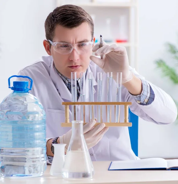 Jeune étudiant chimiste expérimentant en laboratoire — Photo