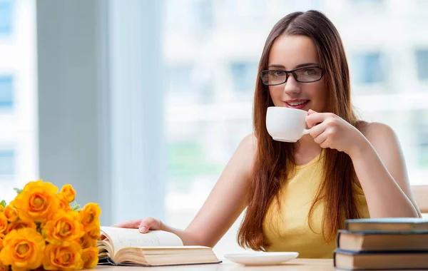 Young student drinking coffee while sudying