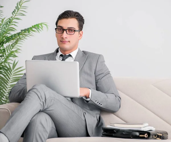 Бізнесмен з ноутбуком, сидячи в дивані — стокове фото